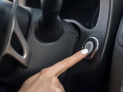 Starter motor repair in Liverpool. Woman pushing start button inside a car checking if it starts.